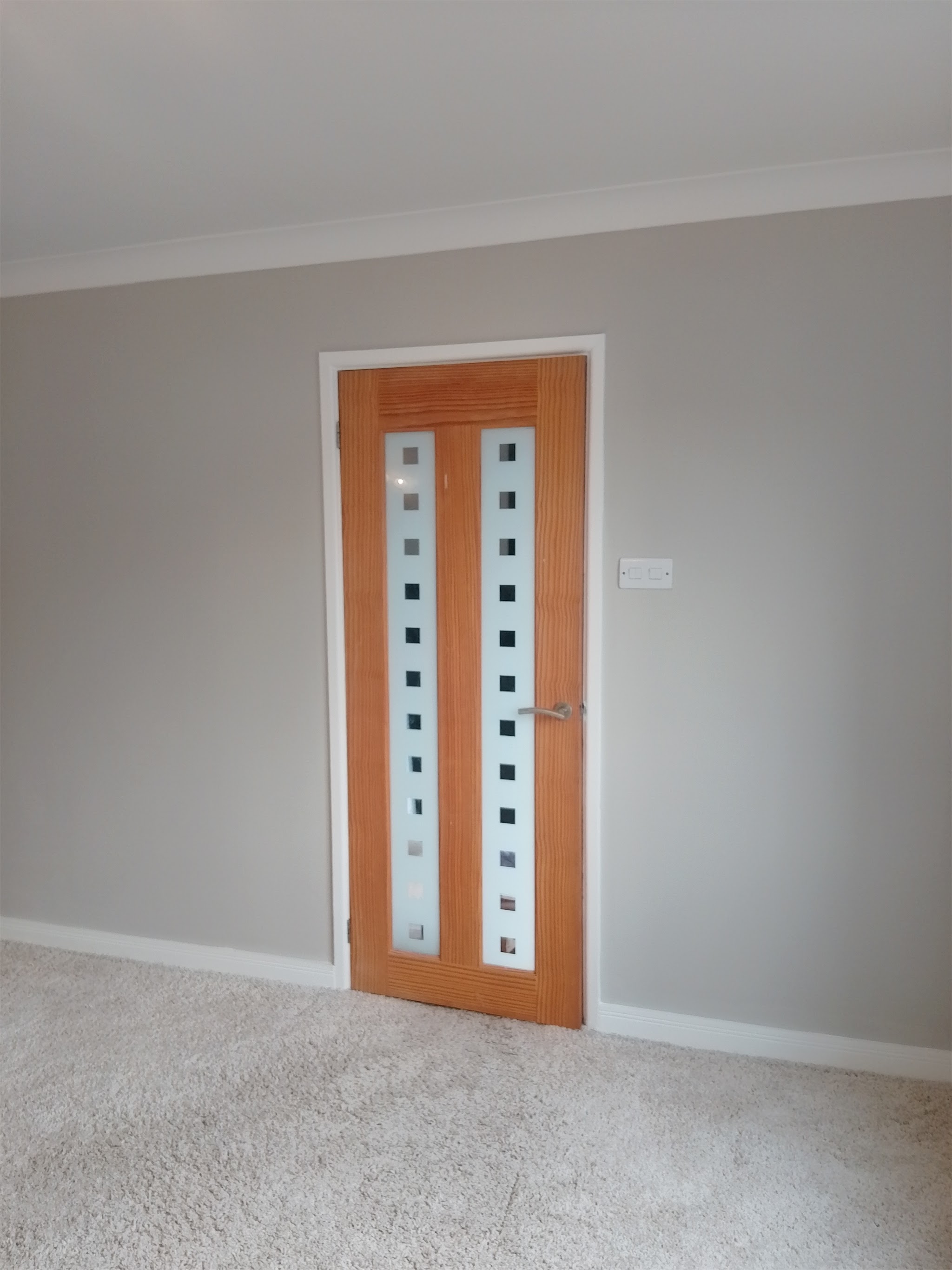 Warm grey room with an oak glazed door and crisp white skirting