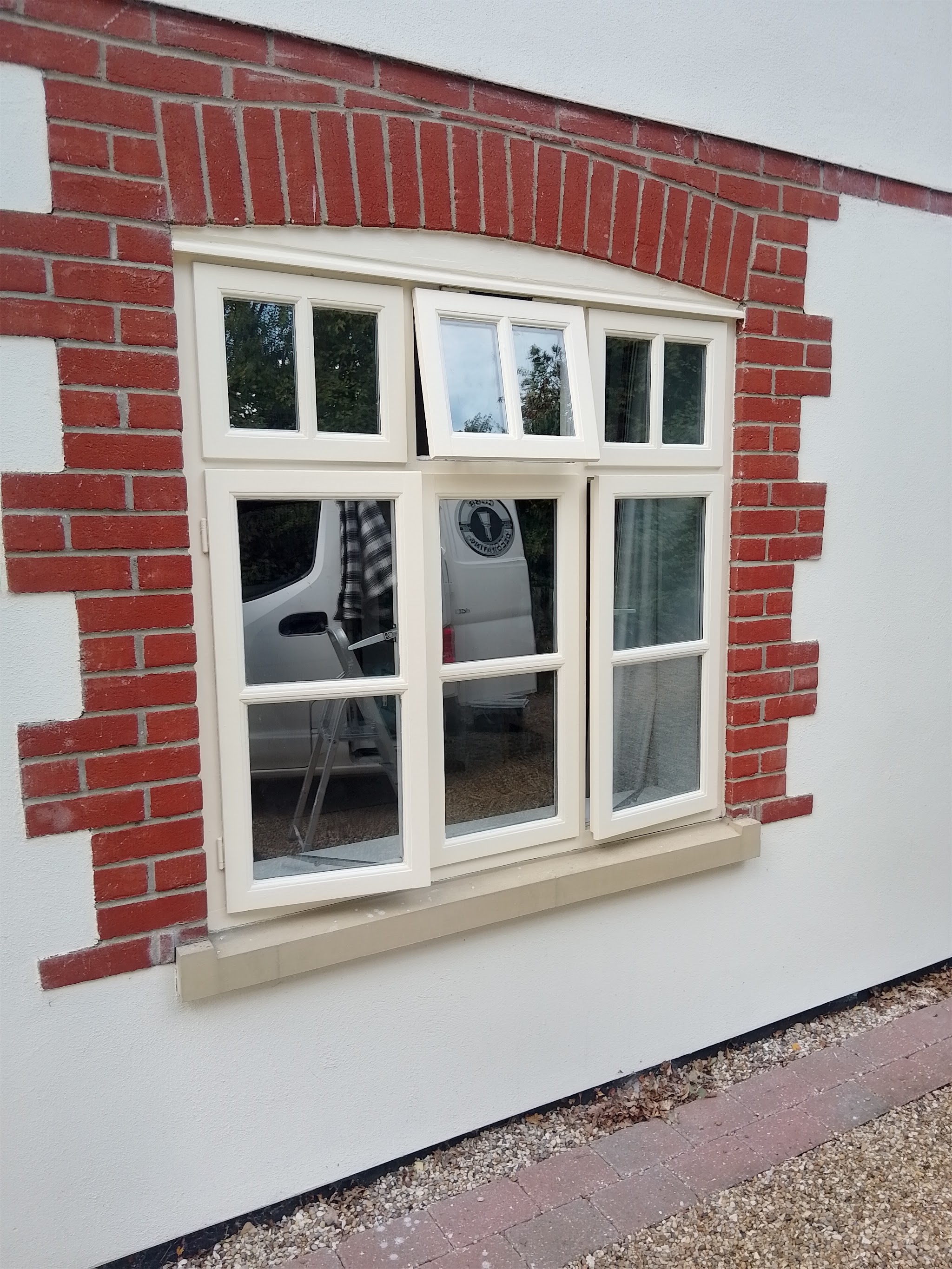 Close-up of crisp white render around a red-brick window arch